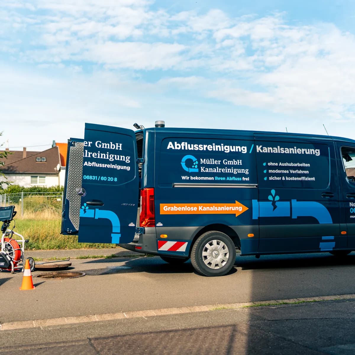 Einsatzfahrzeug der Müller GmbH am geöffneten Schacht in der Wohnstraße
