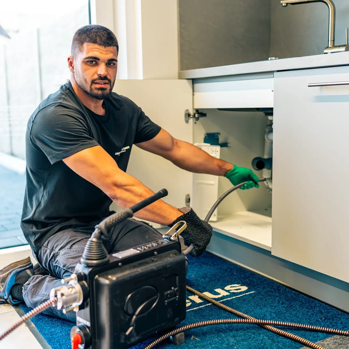 Monteur der Müller GmbH öffnet eine Abflussleitung mit der elektrischen Spirale